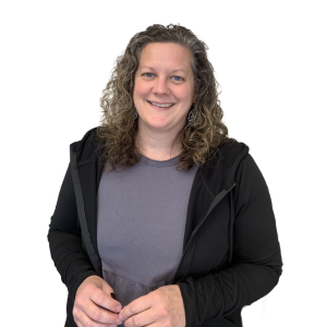 A woman wearing a black hoodie and a grey shirt smiles for the camera