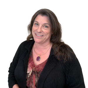 A woman wearing a black sweater and a purple necklace smiles for the camera