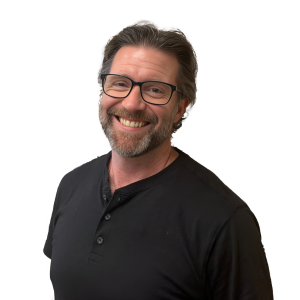 A man wearing glasses and a black shirt smiles for the camera