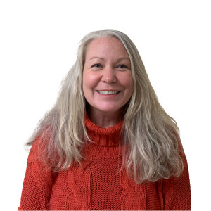 A woman wearing an orange sweater is smiling for the camera