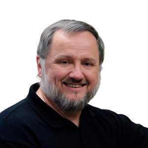 A man with a beard is smiling and wearing a black shirt