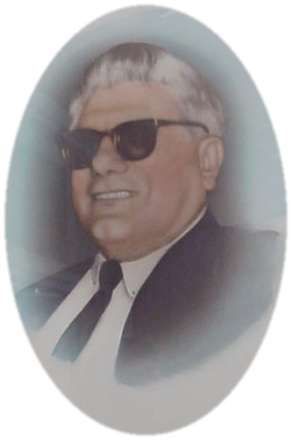 Alfonso Pizza wearing sunglasses and a suit and tie is smiling in a portrait