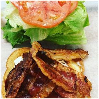 A close up of a sandwich with lettuce, tomato, bacon and cheese