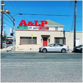 A car parked in front of a building that says a&lp foods