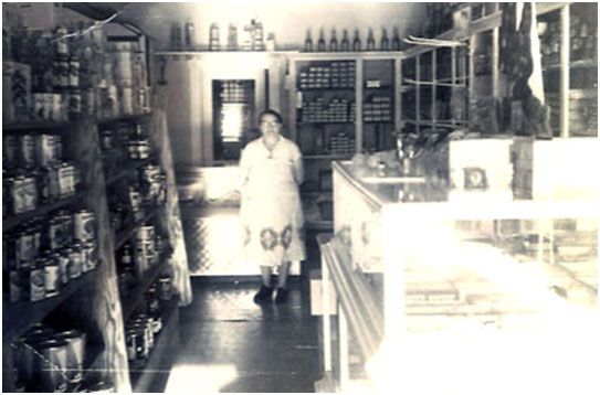 A black and white photo of a woman inside a&lp foods