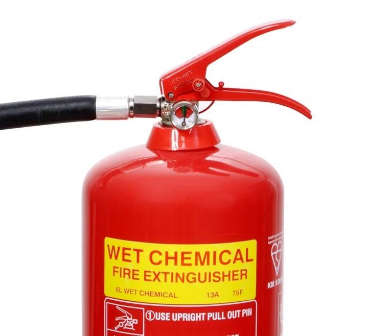 A red wet chemical fire extinguisher with a black handle