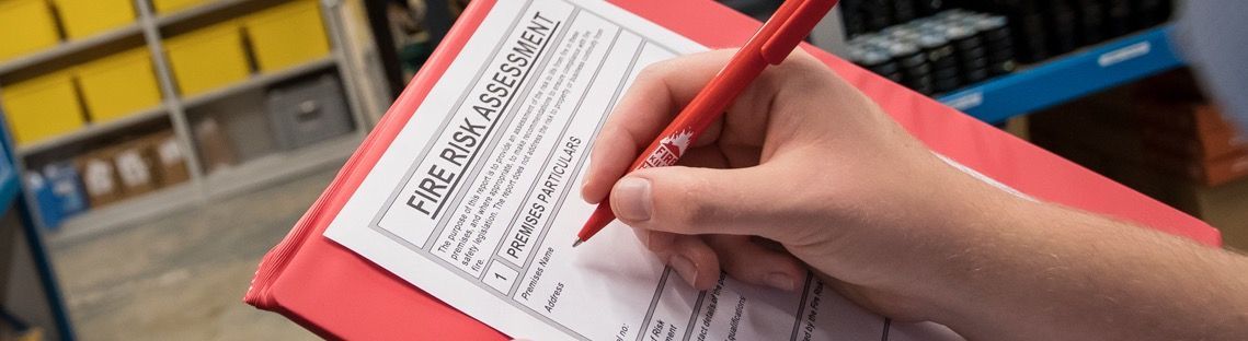 A person is writing on a piece of paper with a pen.