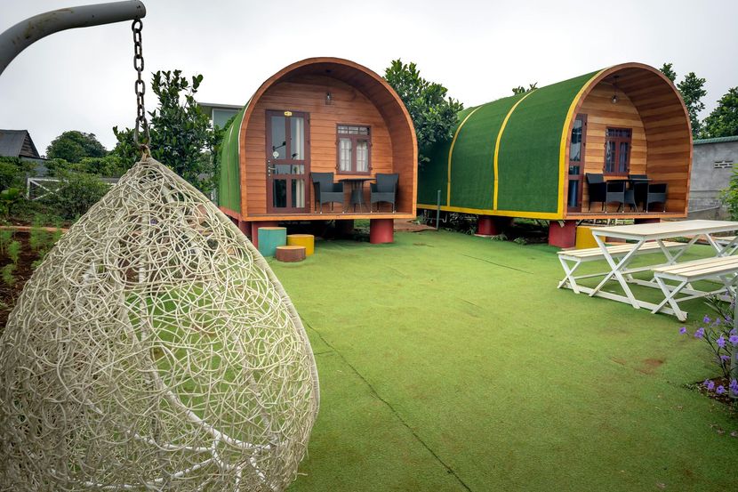 A couple of small wooden houses sitting on top of a lush green field.