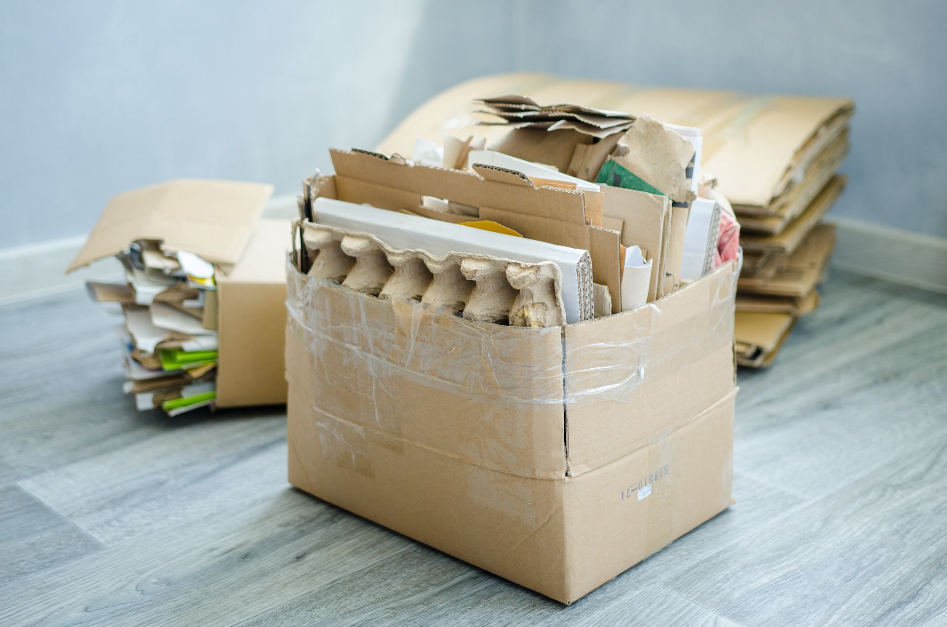 A cardboard box filled with cardboard boxes on a wooden floor.