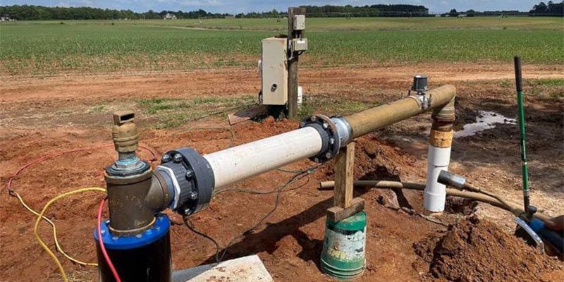 A pipe is sitting in the middle of a dirt field.