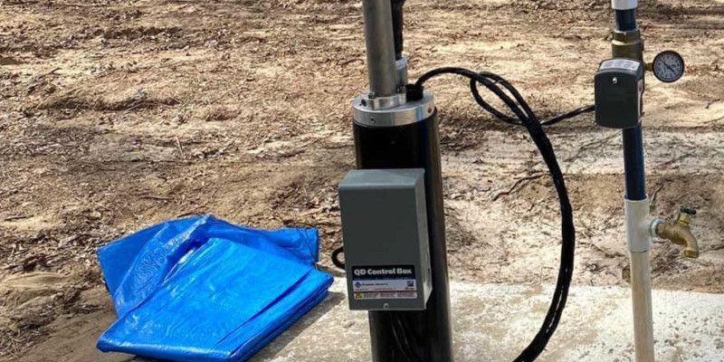 A blue tarp is laying on the ground next to a water pump.