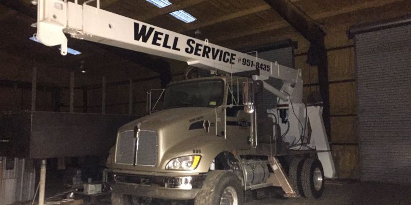 A well service truck is parked in a warehouse