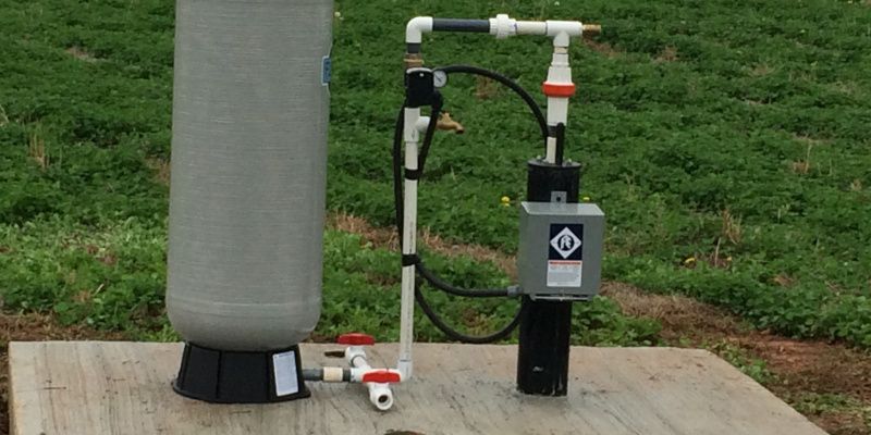 A water pump is sitting on top of a wooden platform.