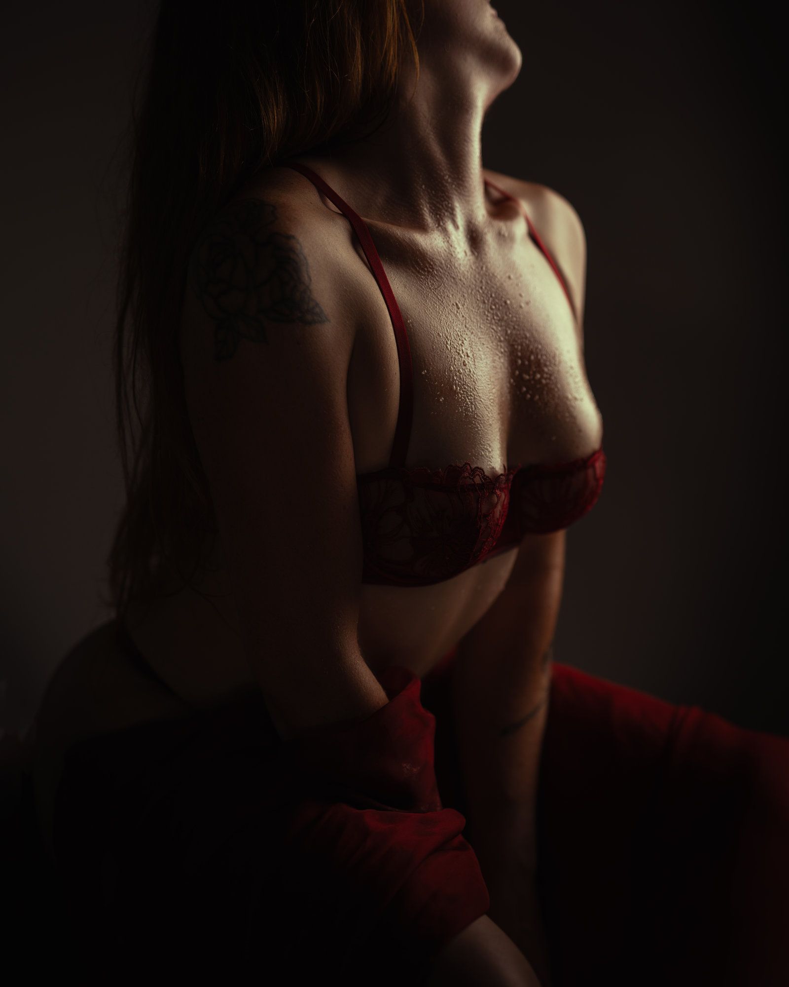 Femme portant de la lingerie blanche, dos à la caméra, tatouages ​​dans le dos, accroupie.