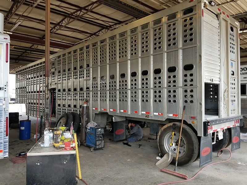 A man is working on a trailer in a garage