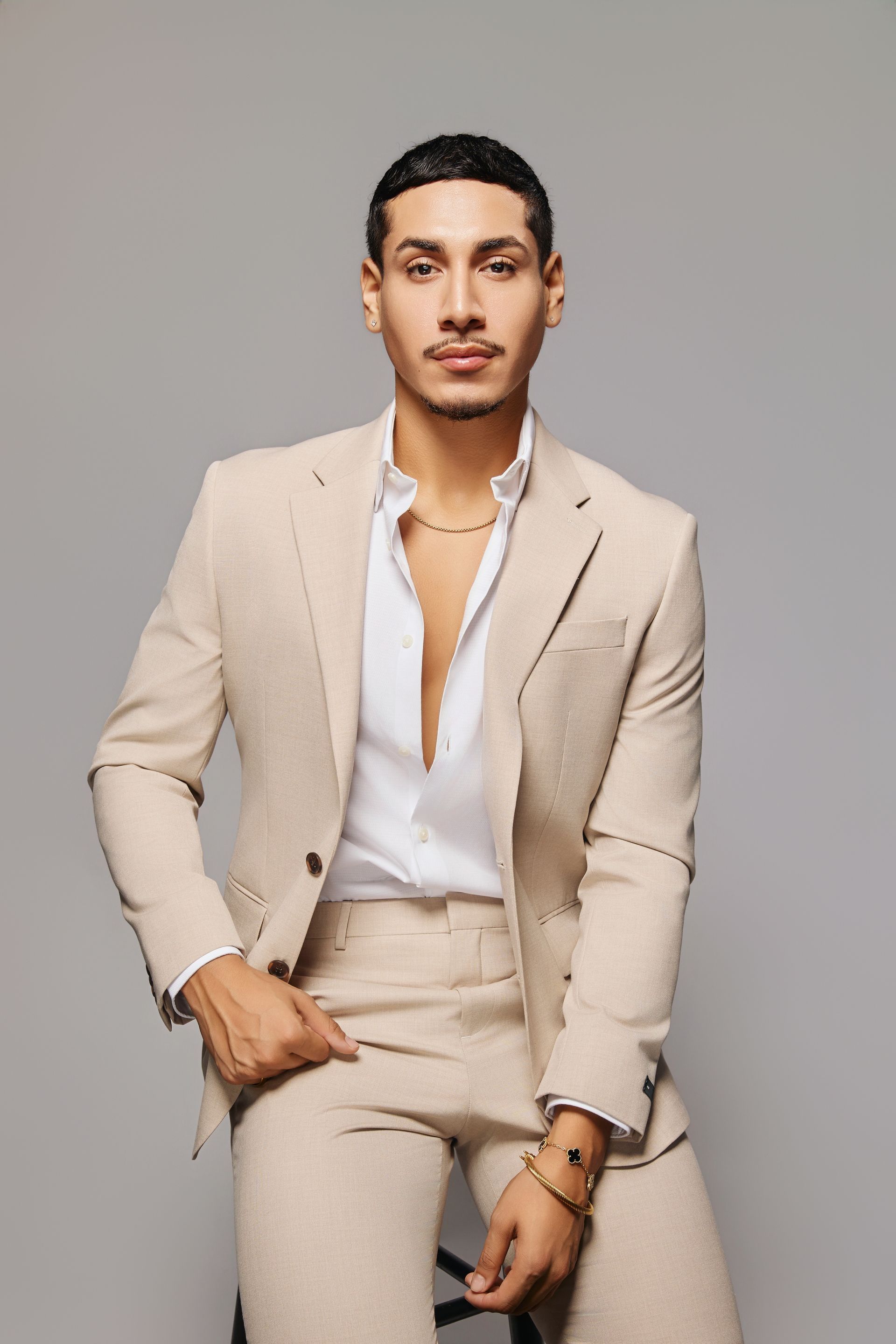 A woman is sitting at a desk with a laptop and a vase of flowers.