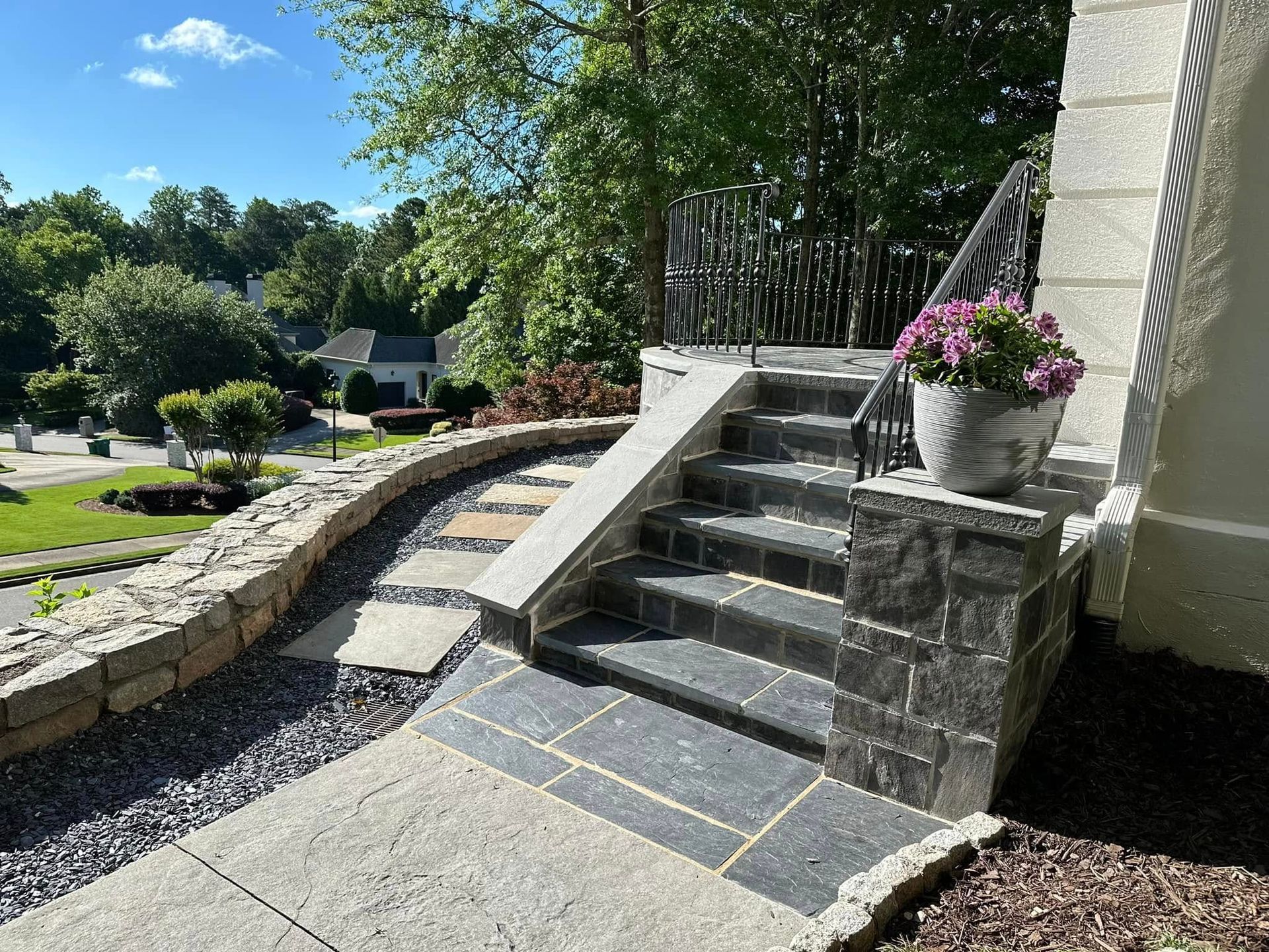 A set of stairs leading up to a house with flowers in a pot.