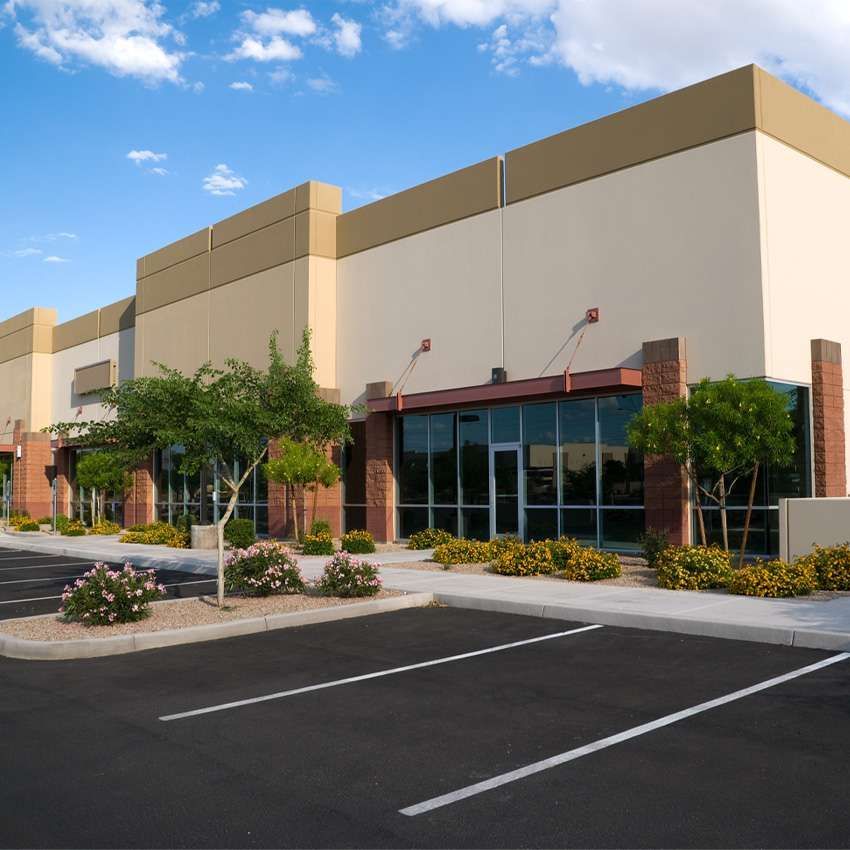 A large building with a lot of windows and a parking lot in front of it