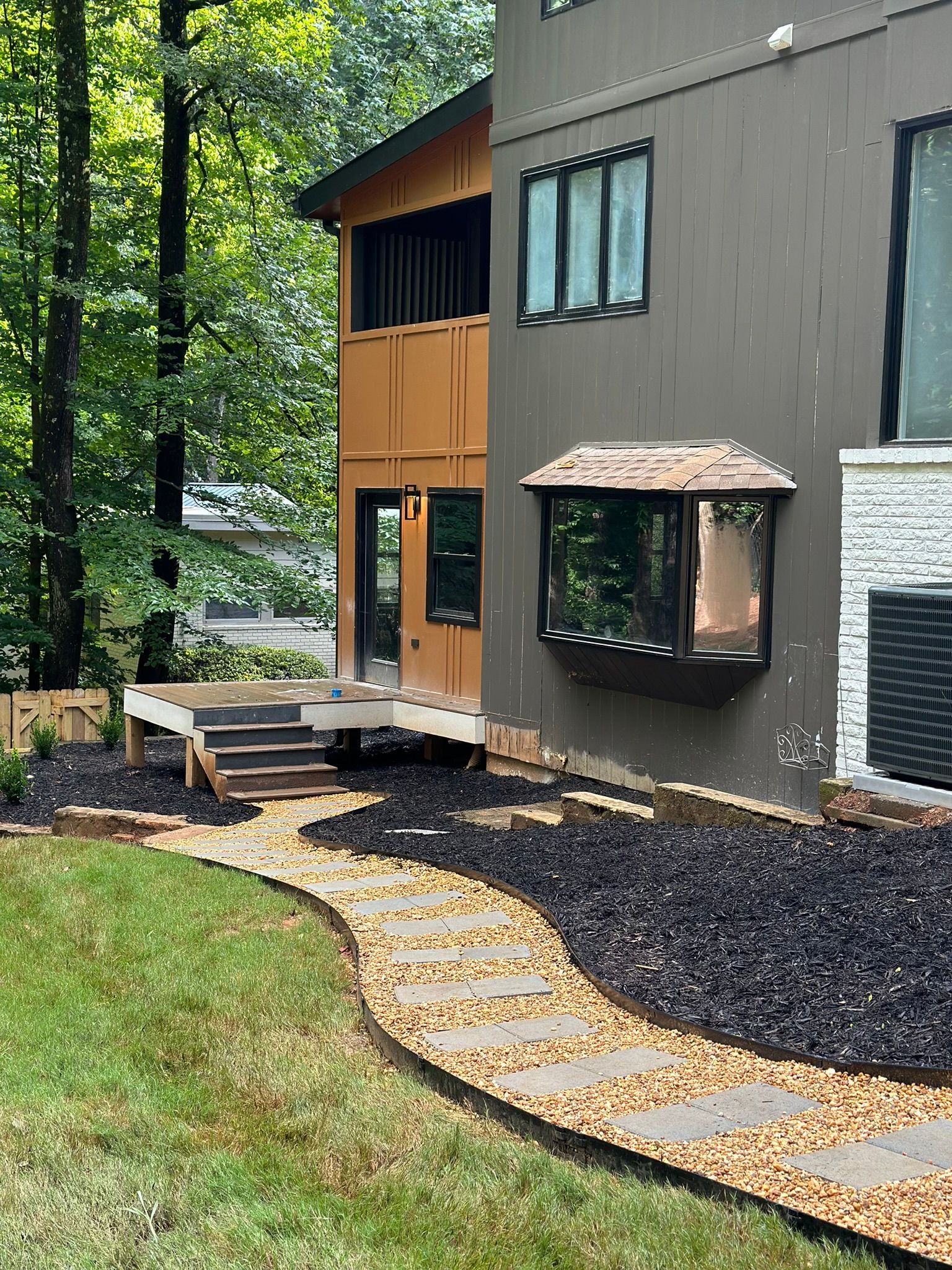 A house with a walkway leading to it and a large window.