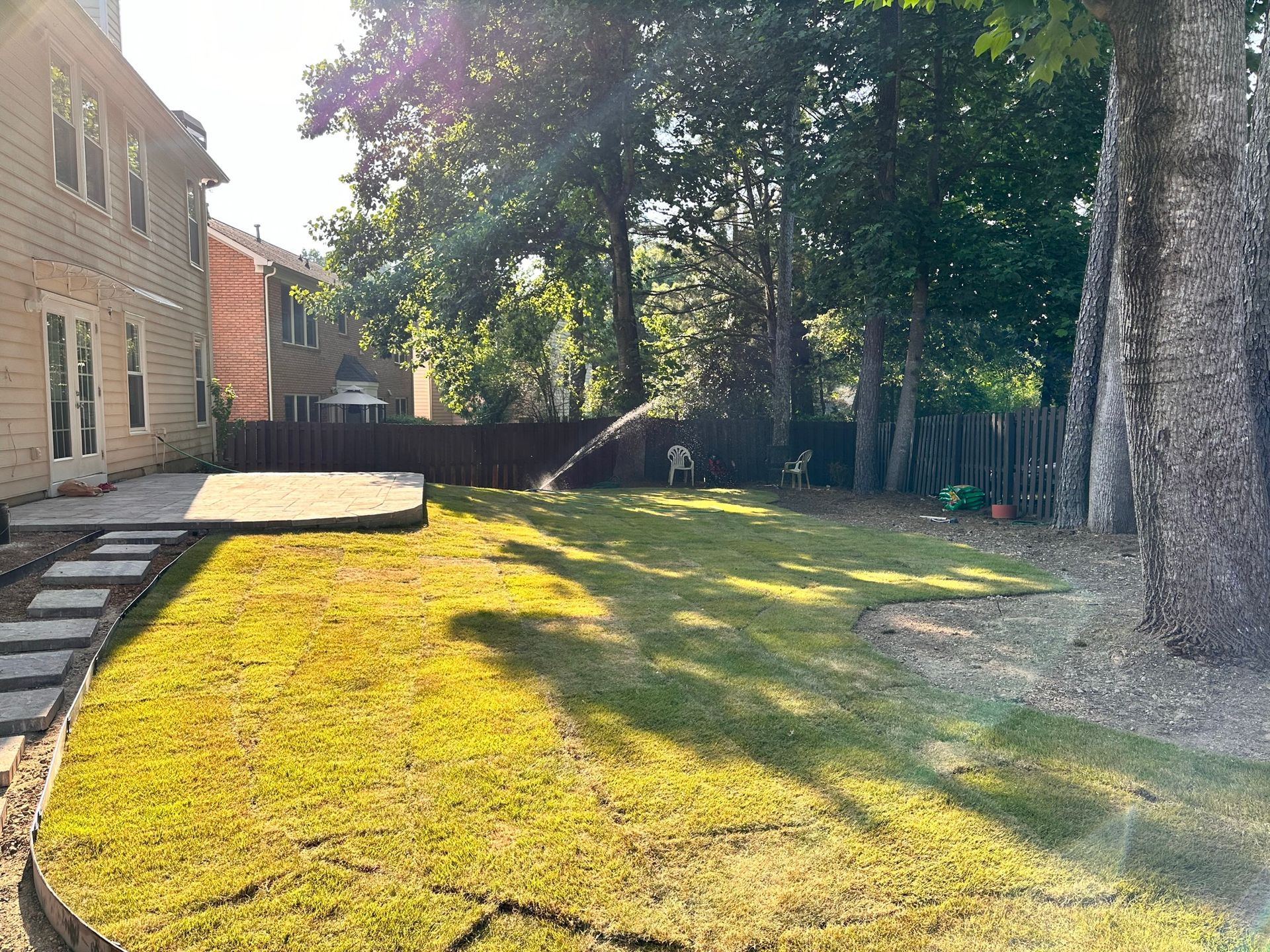 The backyard of a house with a lot of grass and trees.