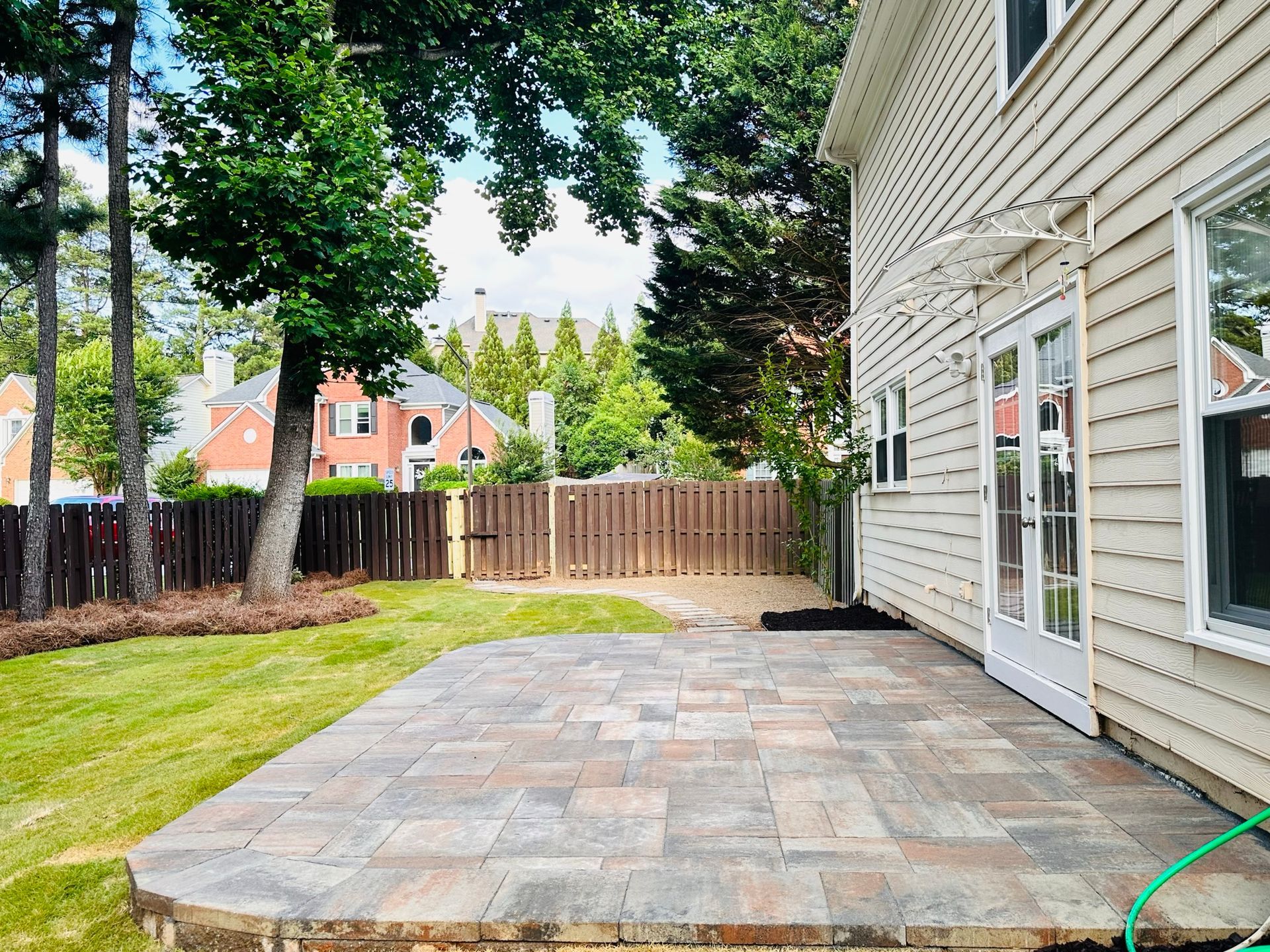 There is a patio in the backyard of a house.