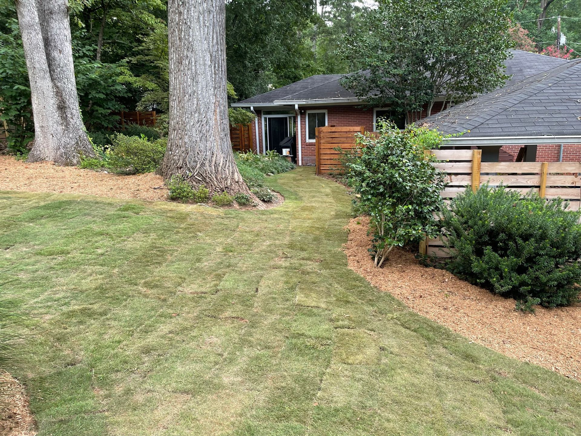 A house with a lush green lawn in front of it.