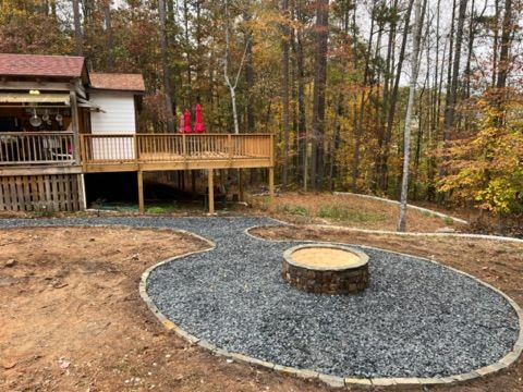 There is a fire pit in the middle of the yard in front of a house.
