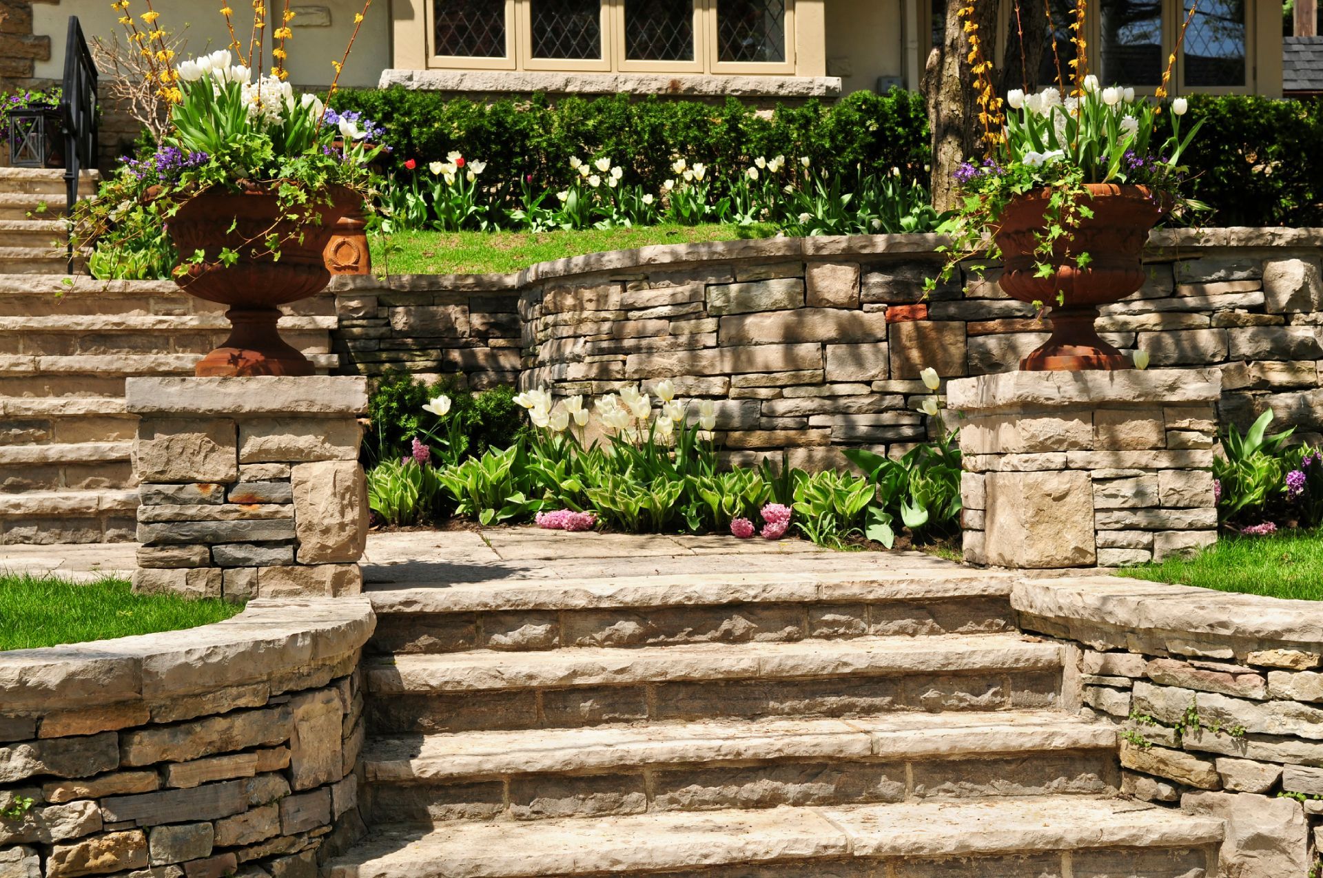 A stone wall with stairs leading up to a house