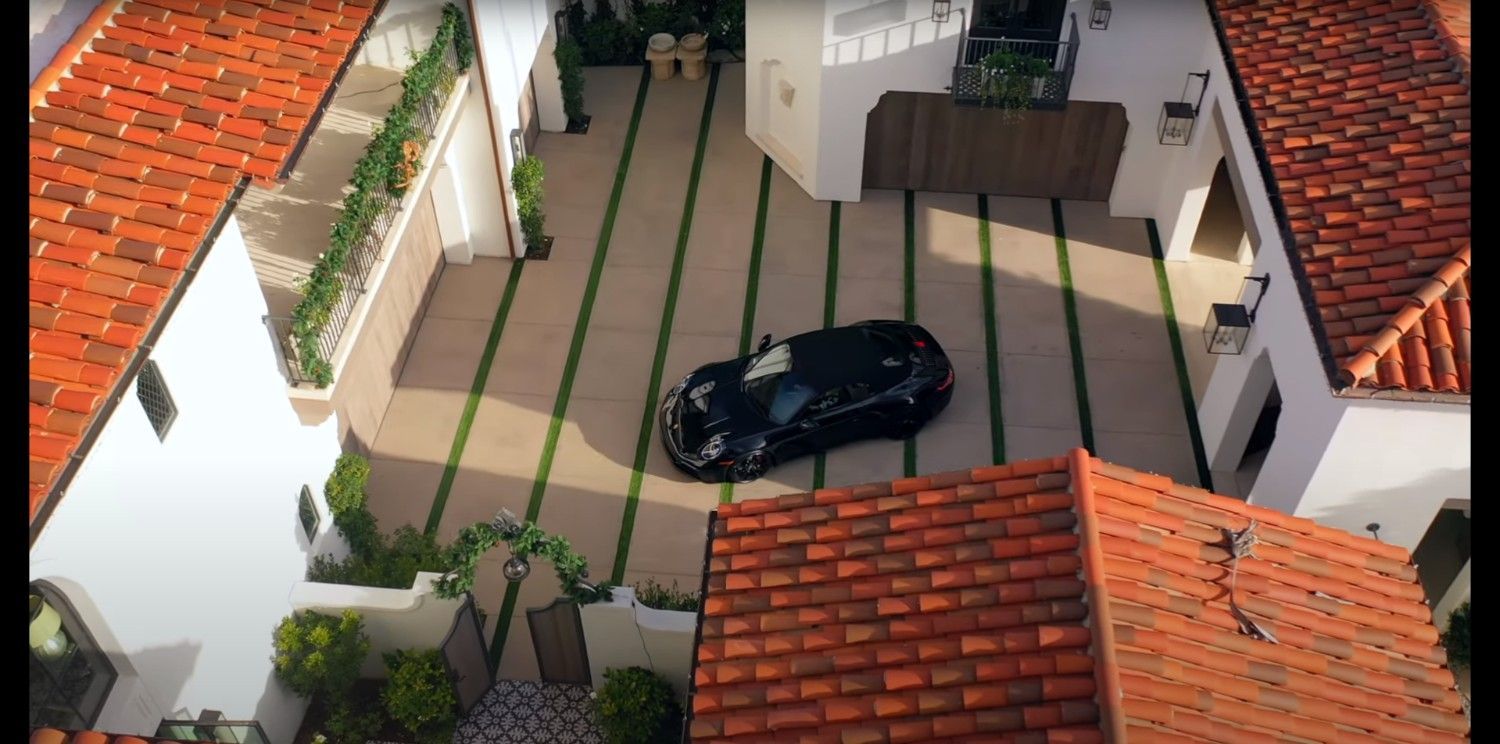 An aerial view of a car parked in the driveway of a house.