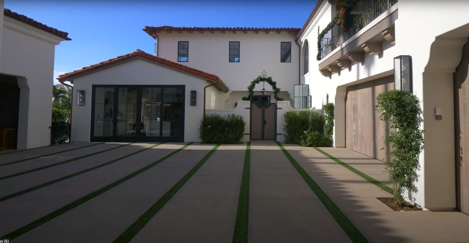 A large white house with a large driveway in front of it.