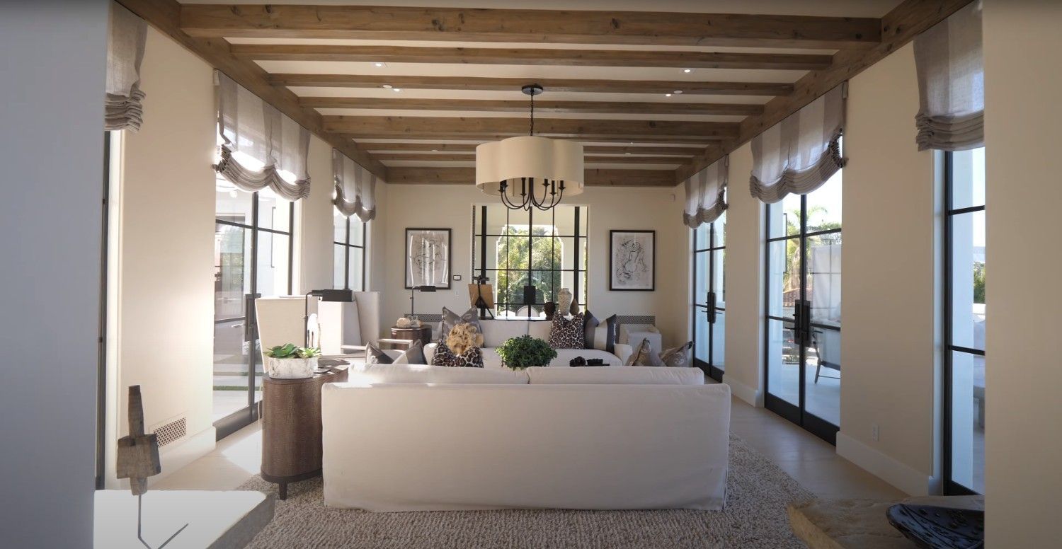 A living room with a large white couch and lots of windows.