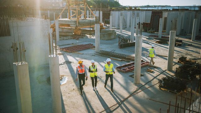 A group of construction workers are walking through a construction site.