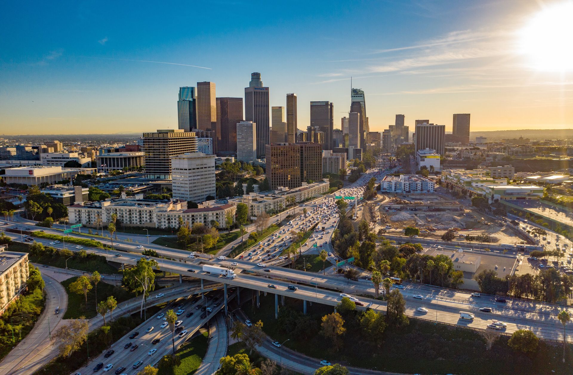 An aerial view of a city skyline with a highway in the foreground.