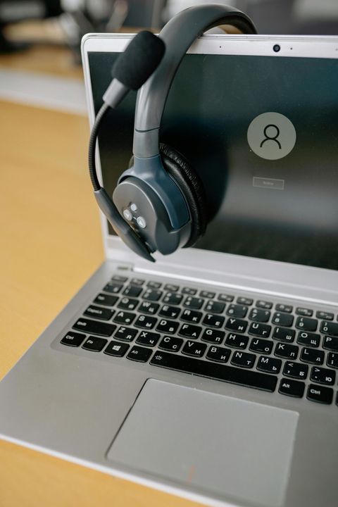 A pair of headphones is sitting on top of a laptop computer.