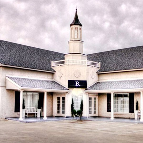 Rivercrest is a large white building with the letter r on the front