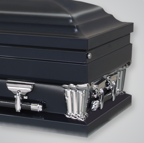 A black coffin with silver trim sits on a white surface