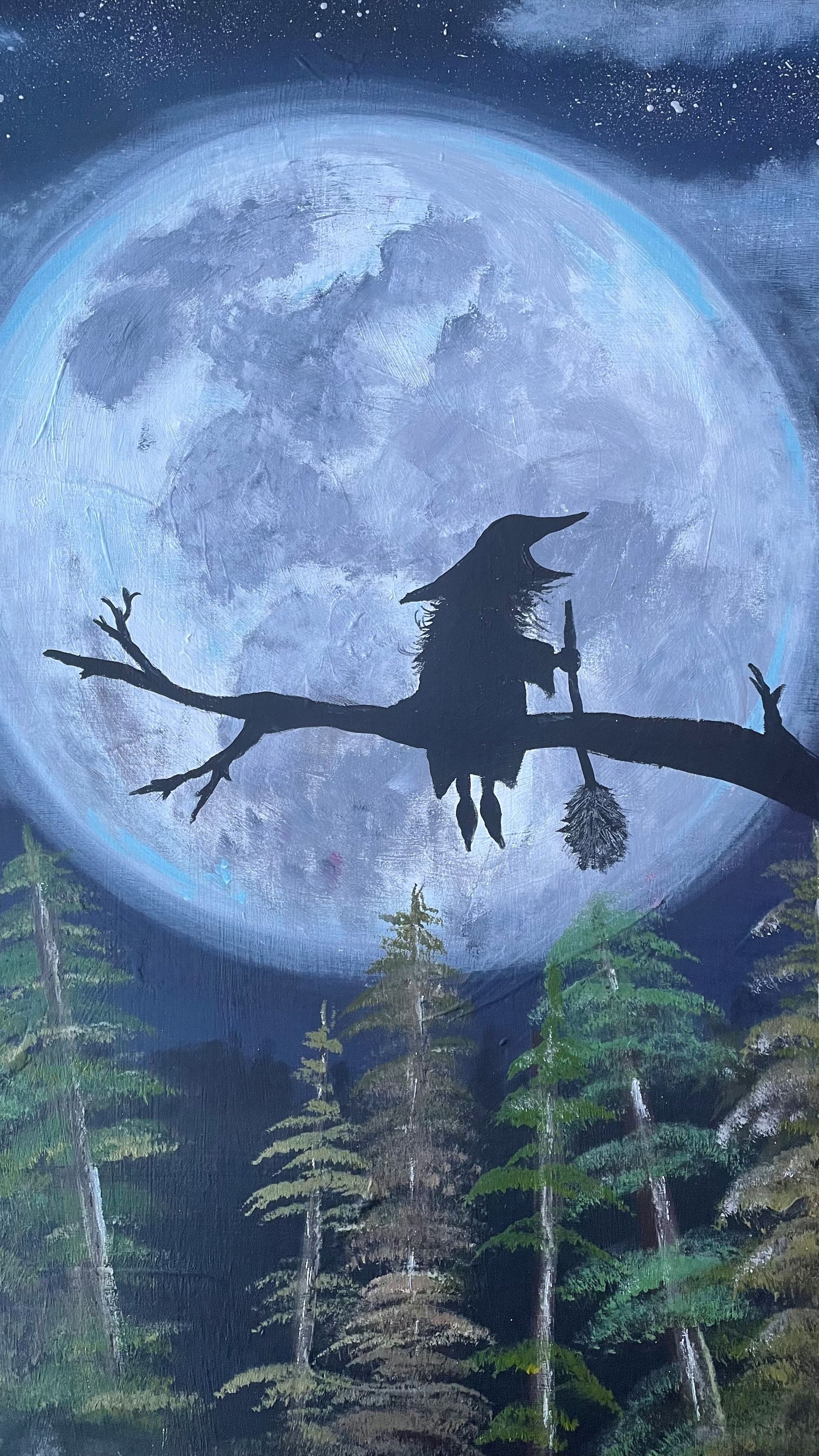 A witch is sitting on a branch in front of a full moon.