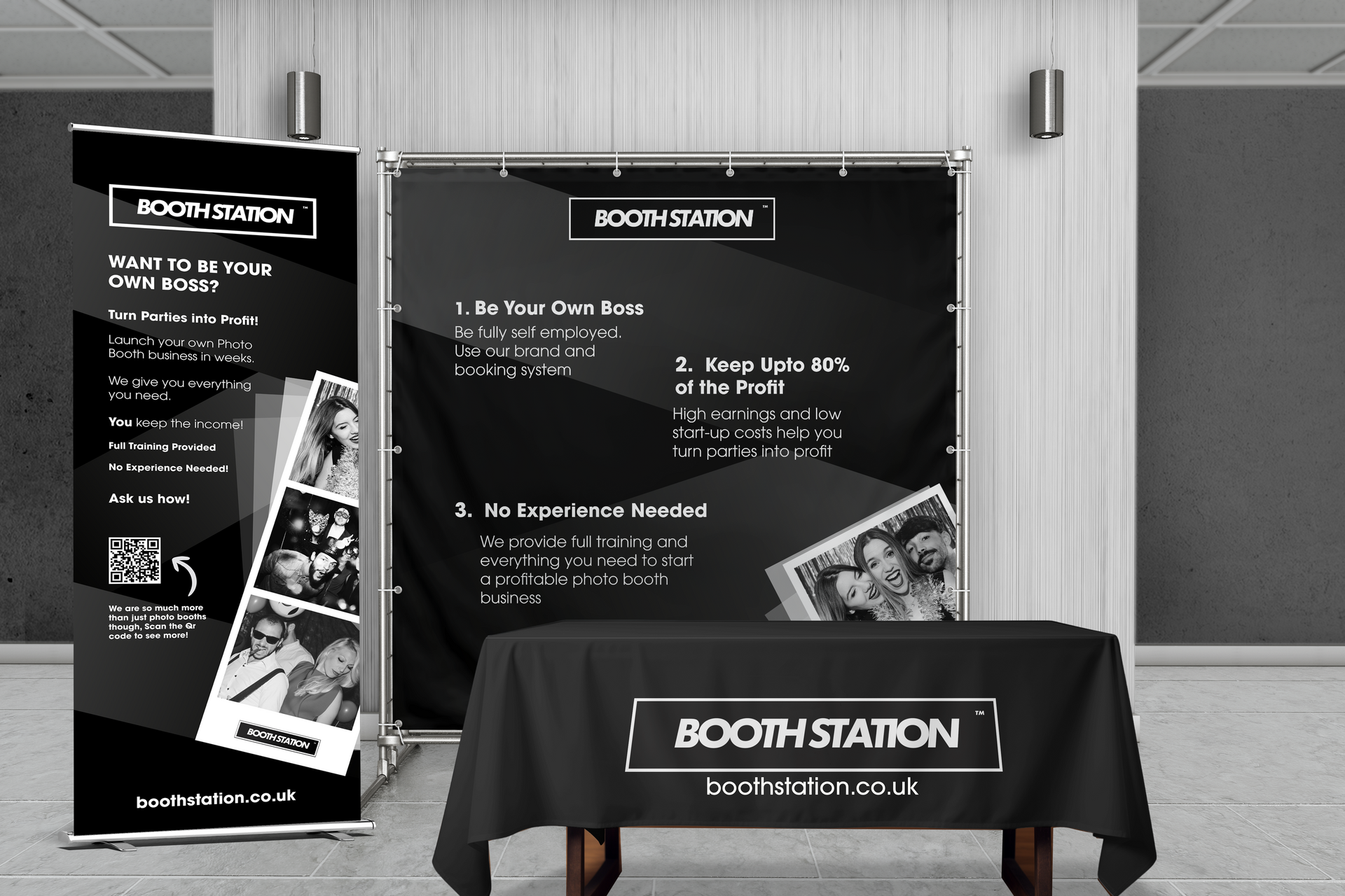 A man is holding a cell phone in front of a laptop