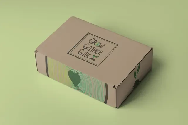 A cardboard box with the words `` grow gather give '' on it is sitting on a green surface.