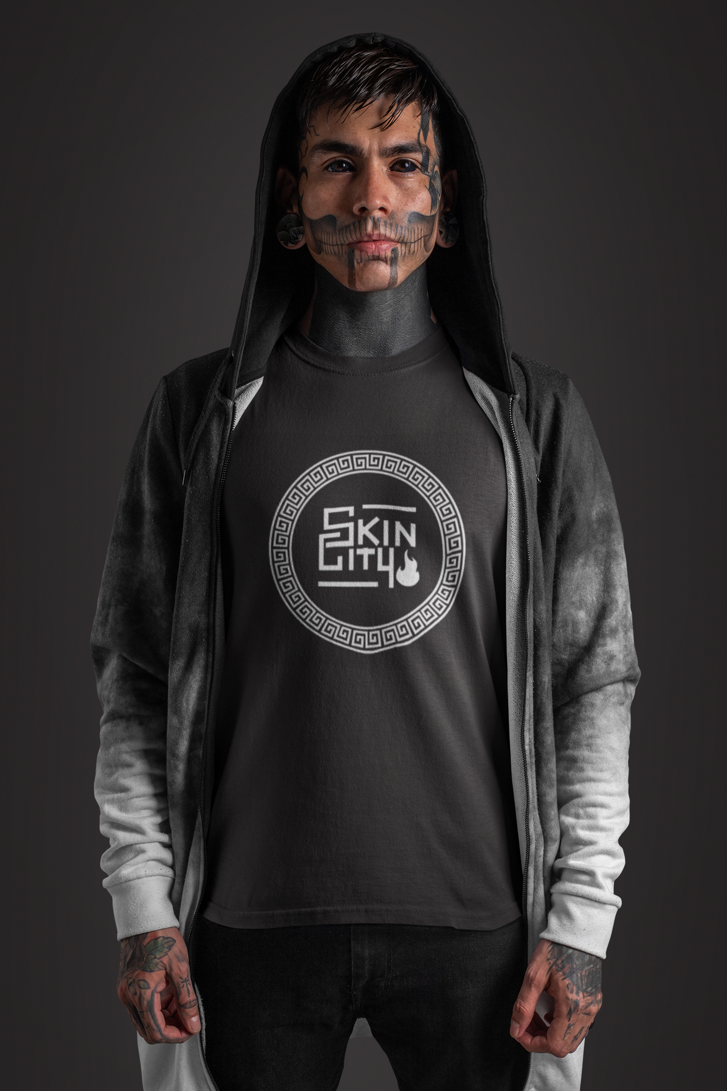 A man with tattoos on his face is wearing a black shirt that says skin city