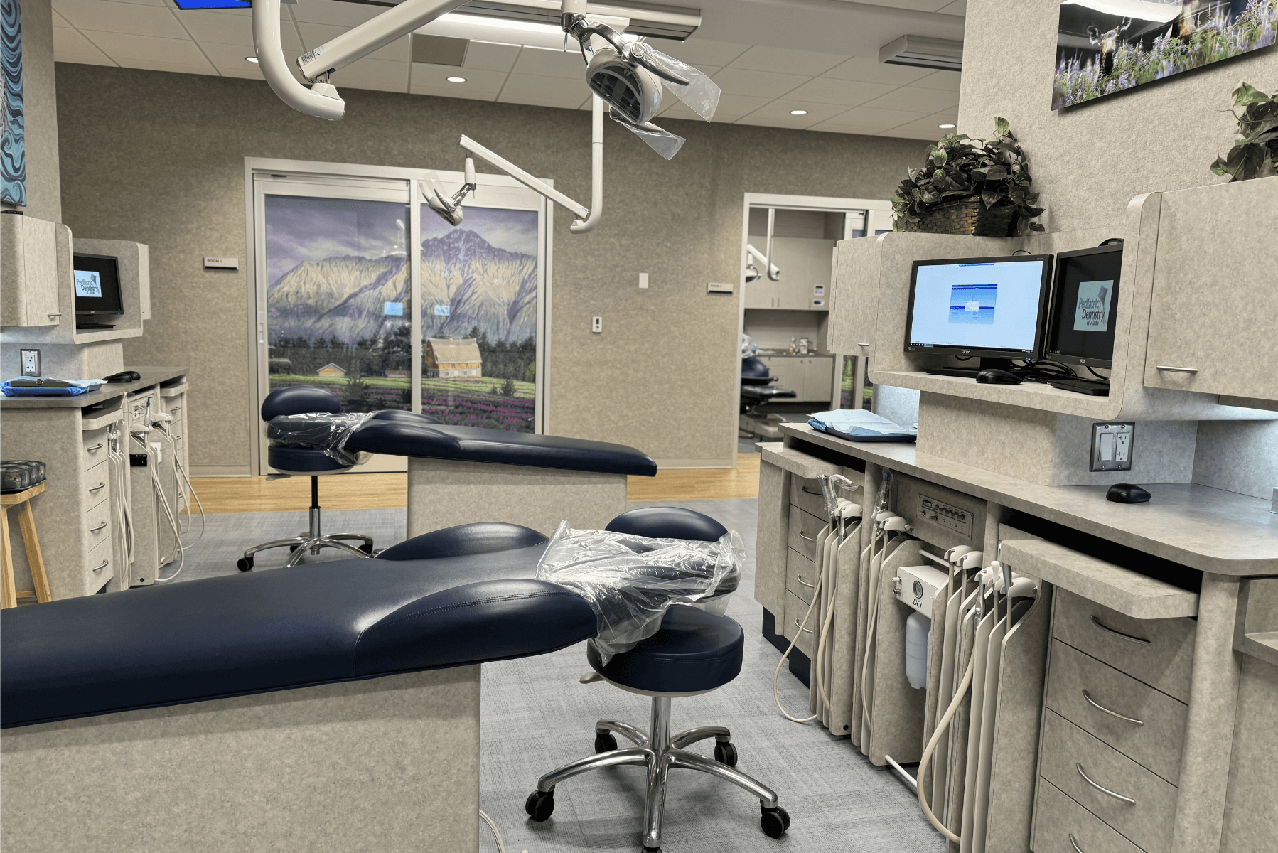 a dental office with two dental chairs and a computer | Pediatric Dentistry of Alaska | Best Pediatric Dentist In Wasilla and Palmer, Alaska