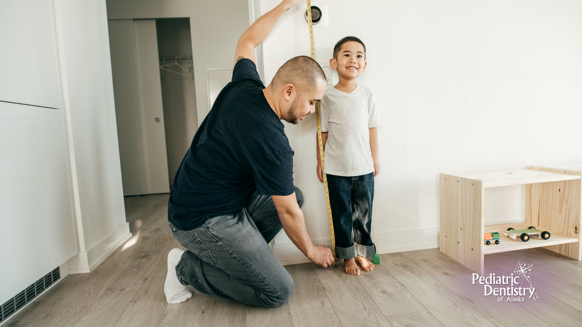 A man is measuring the height of a young boy with a tape measure.