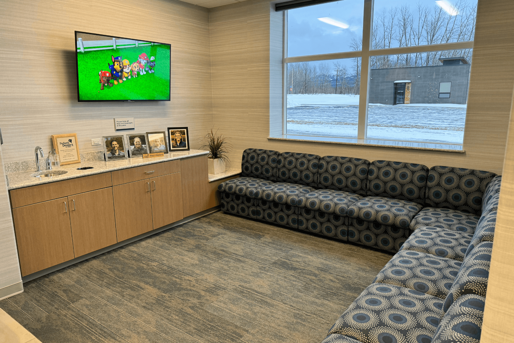 a waiting room with a couch and a television on the wall | Pediatric Dentistry of Alaska | Best Pediatric Dentist In Wasilla and Palmer, Alaska