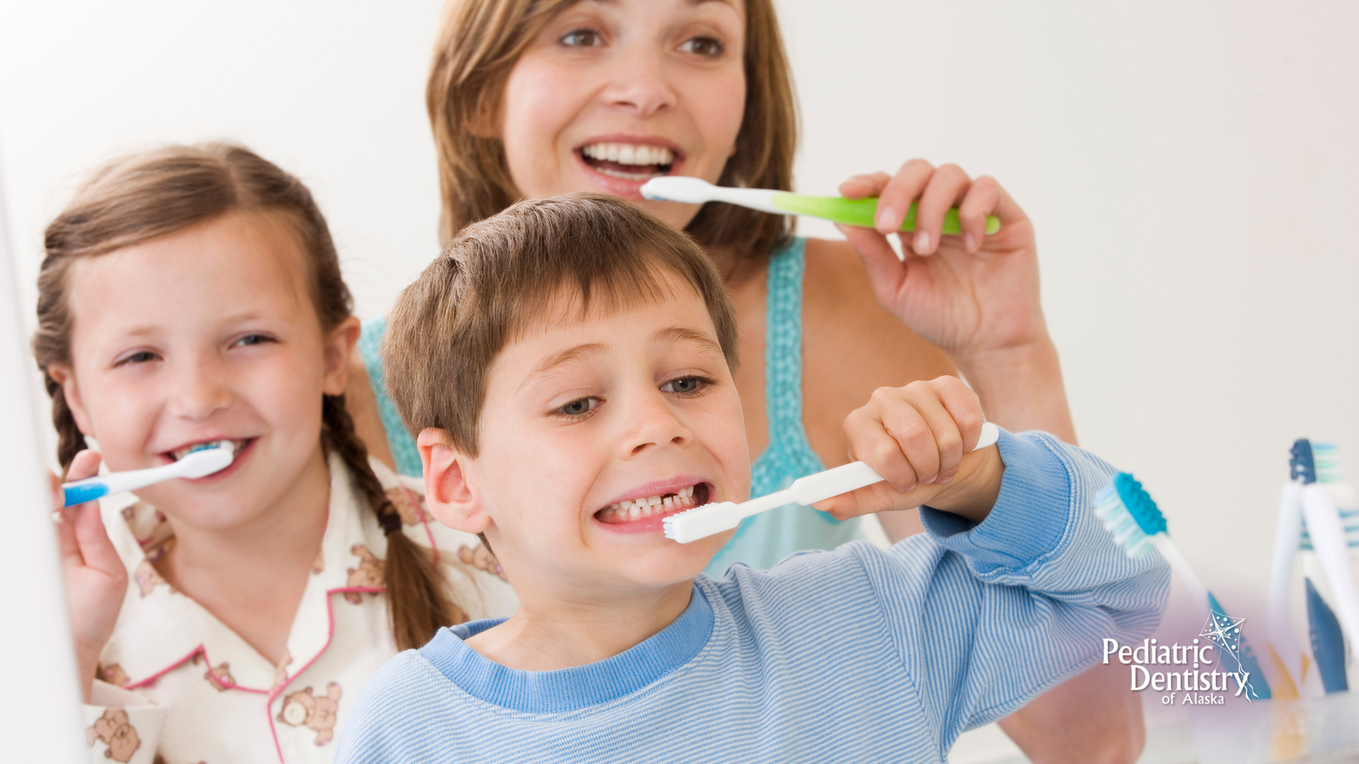 A woman and two children are brushing their teeth together.