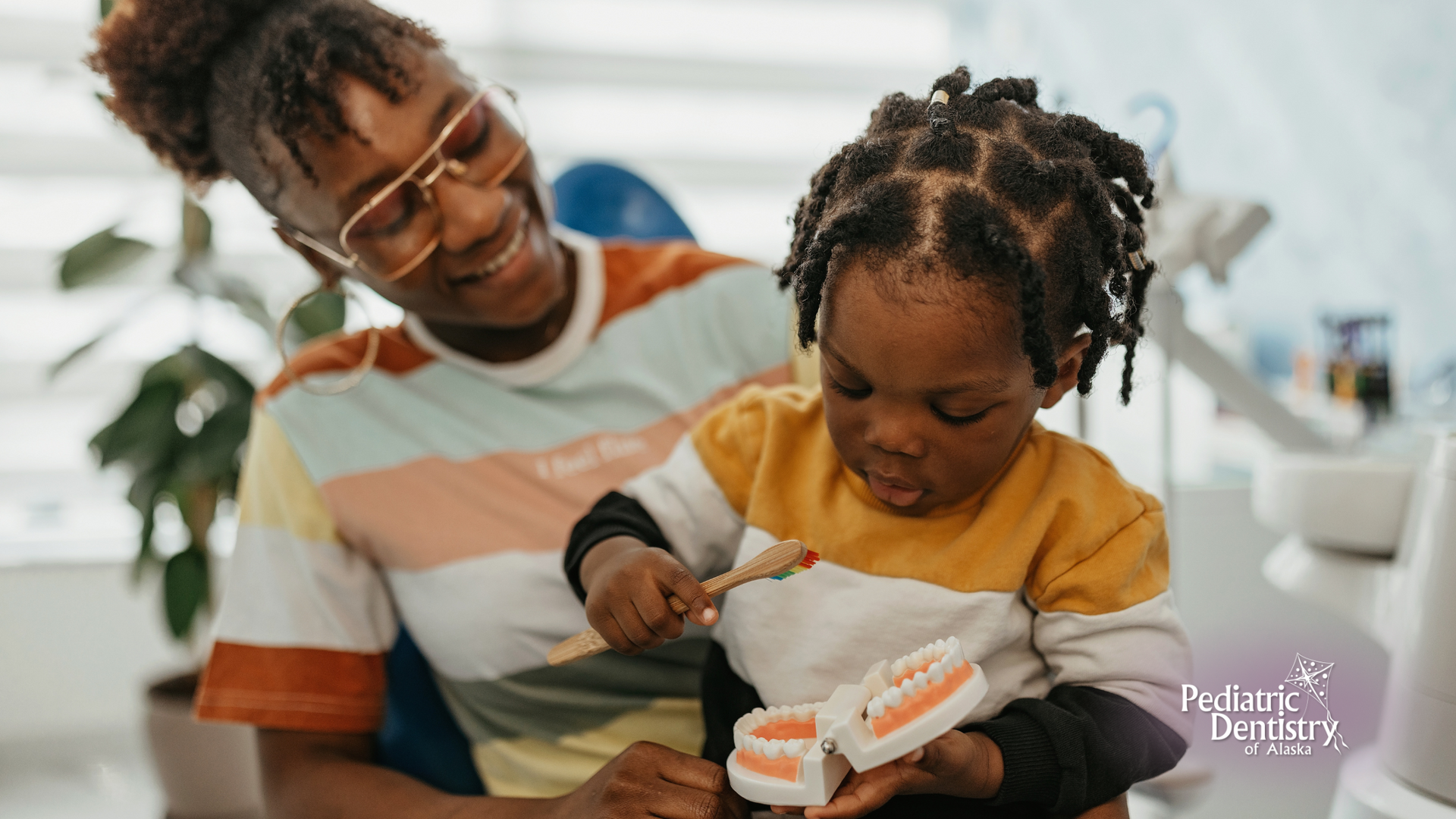 A woman is brushing a child 's teeth with a toothbrush.