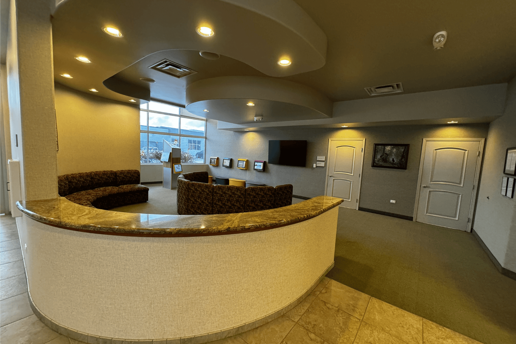 a waiting room with a curved counter and a couch | Pediatric Dentistry of Alaska | Best Pediatric Dentist In Wasilla and Palmer, Alaska