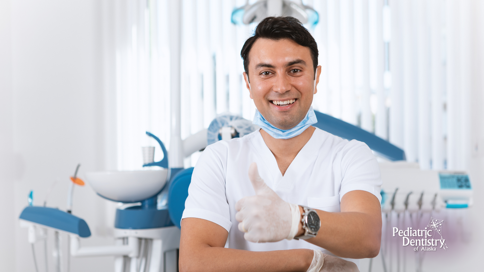 A dentist is giving a thumbs up in a dental office.