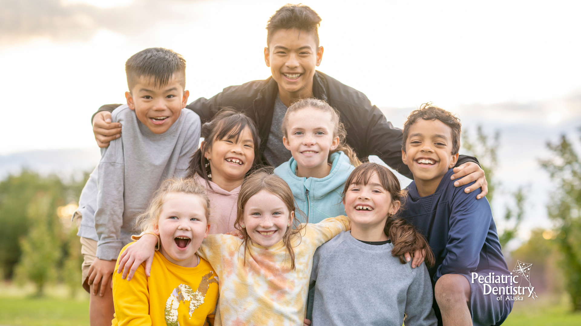 A group of children are posing for a picture together in a park.