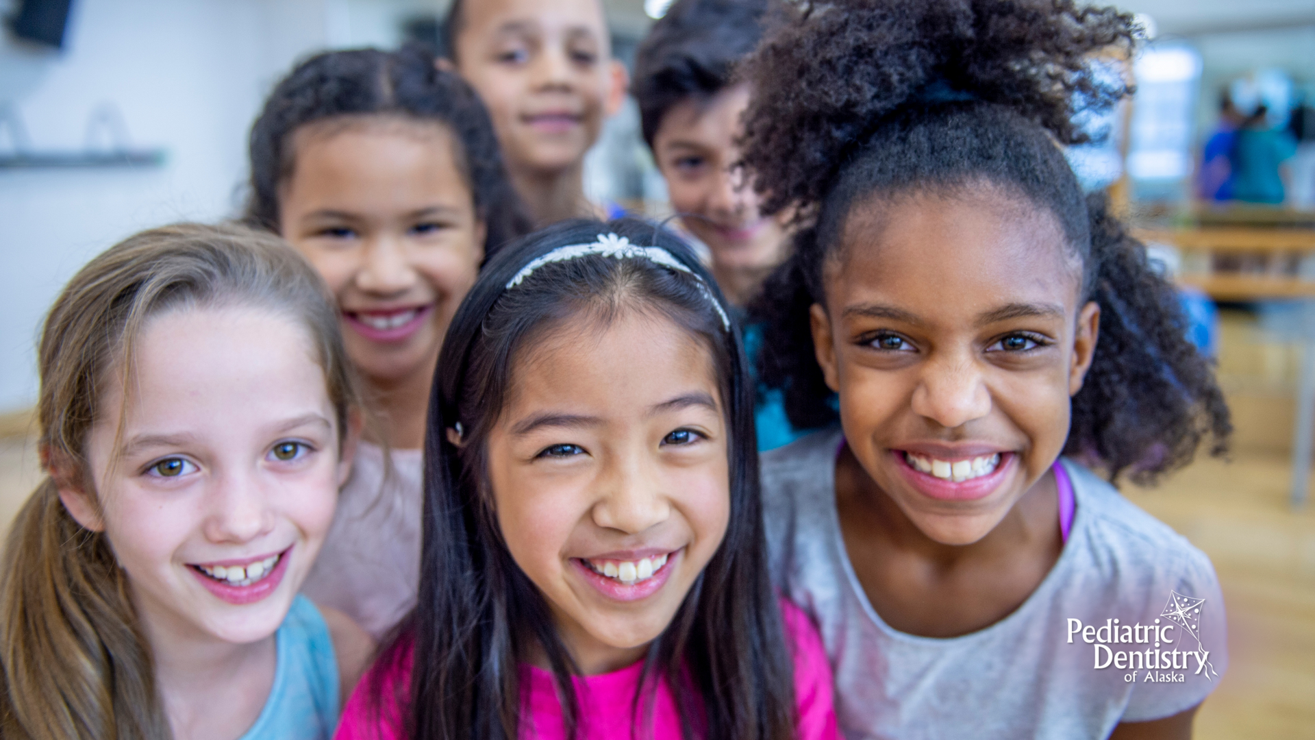 A group of young girls are smiling for the camera.