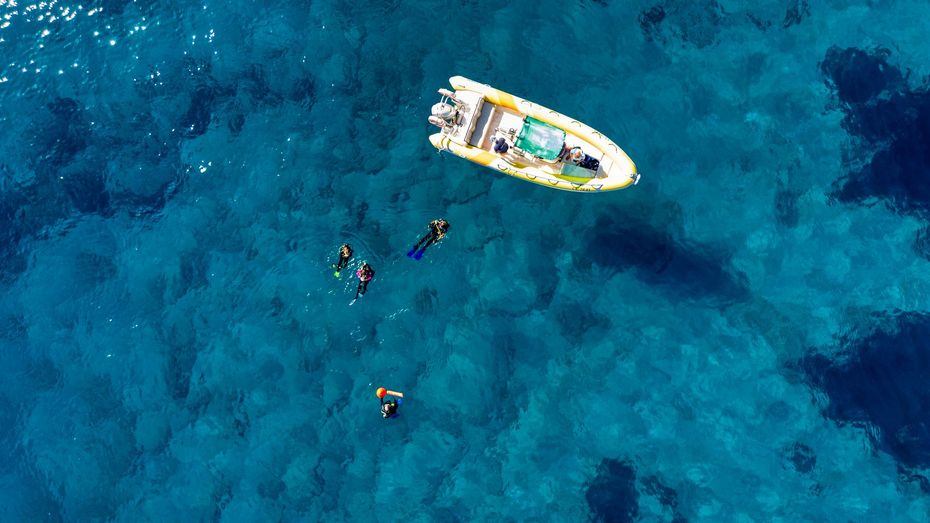A man in a blue shirt is working on a scuba diving cylinder